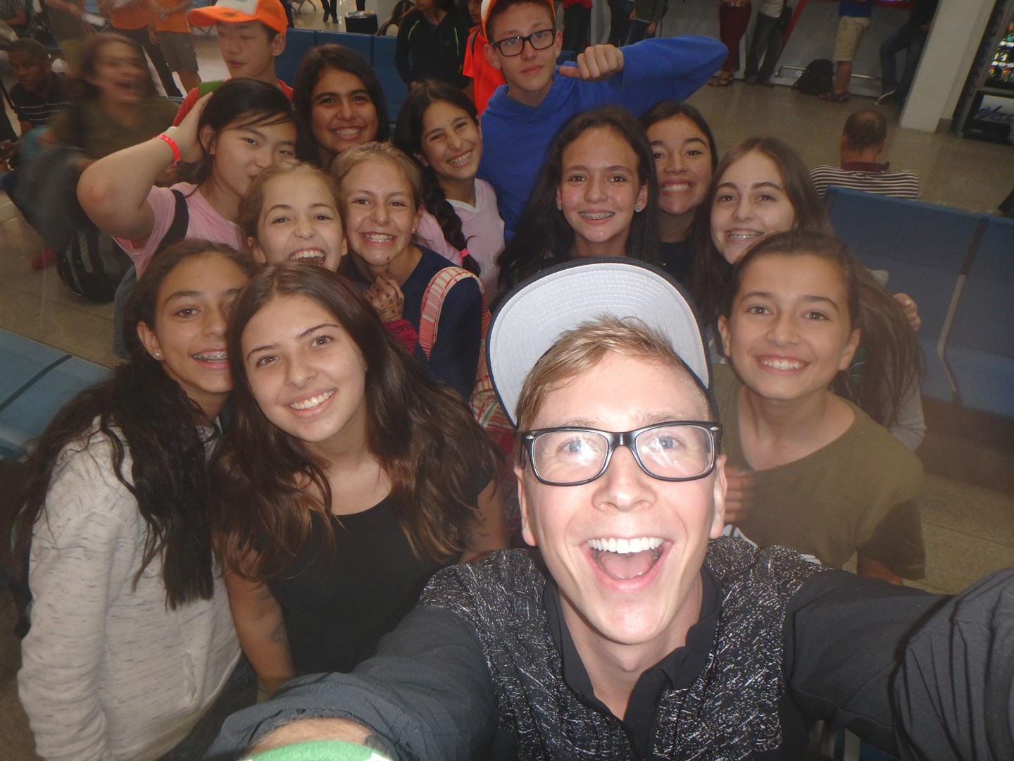 Tyler poses with a gaggle of fans in the airport for the ultimate selfie.